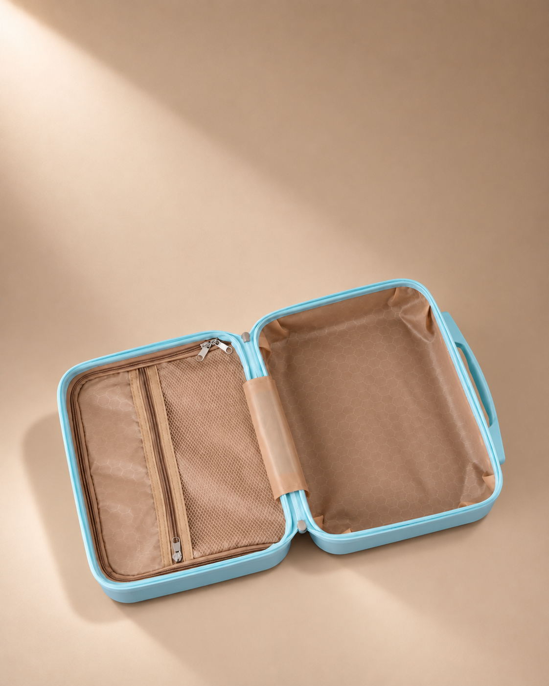 Open blue mini suitcase cosmetic bag showing tan organiser interior and mesh zipper pocket on beige studio background