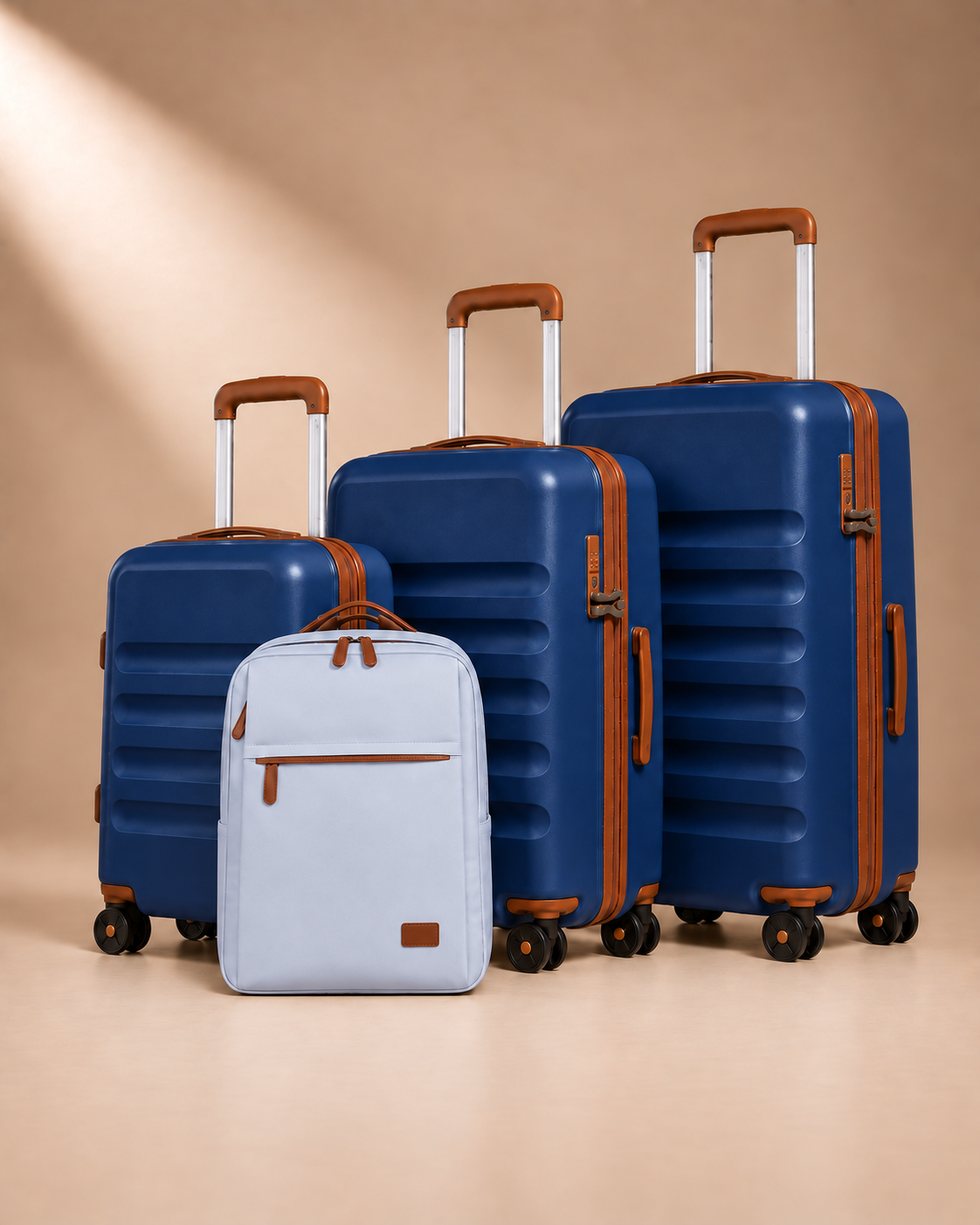 Painswick navy blue hard-shell suitcase set with three wheeled suitcases and a travel backpack with a front zipped pocket.