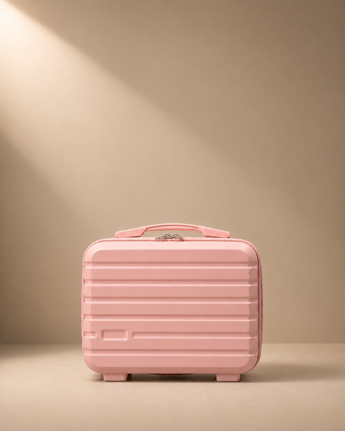 Pink mini suitcase cosmetic bag with hard shell, zip closure and top handle on beige studio background