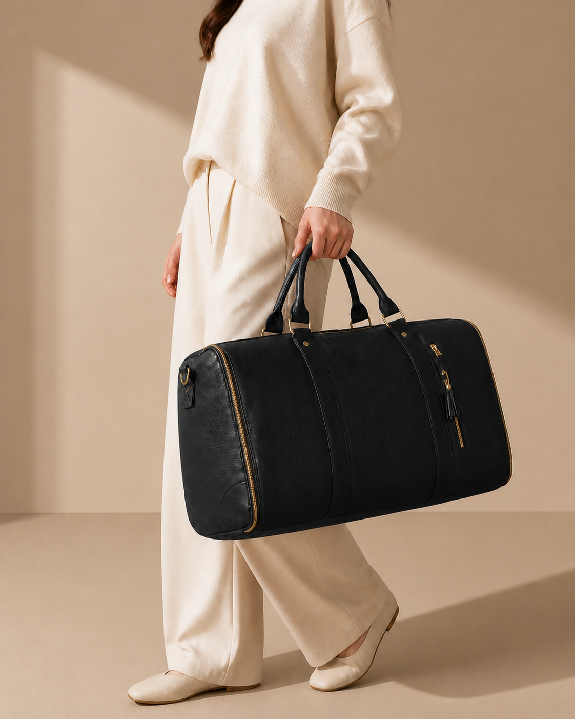 Black garment travel bag carried in a clean premium studio setting