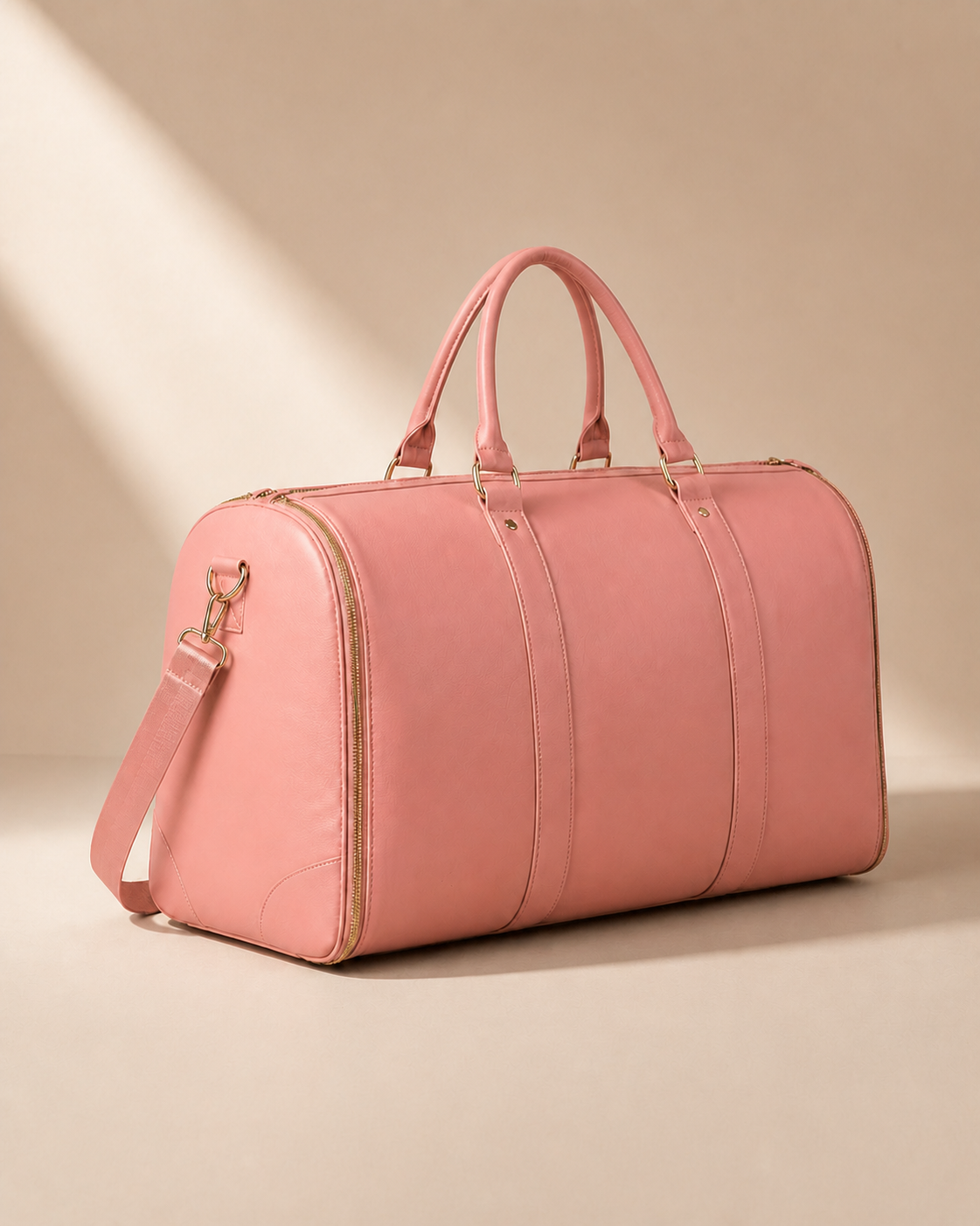 Pink garment travel bag angled view with gold zip detail