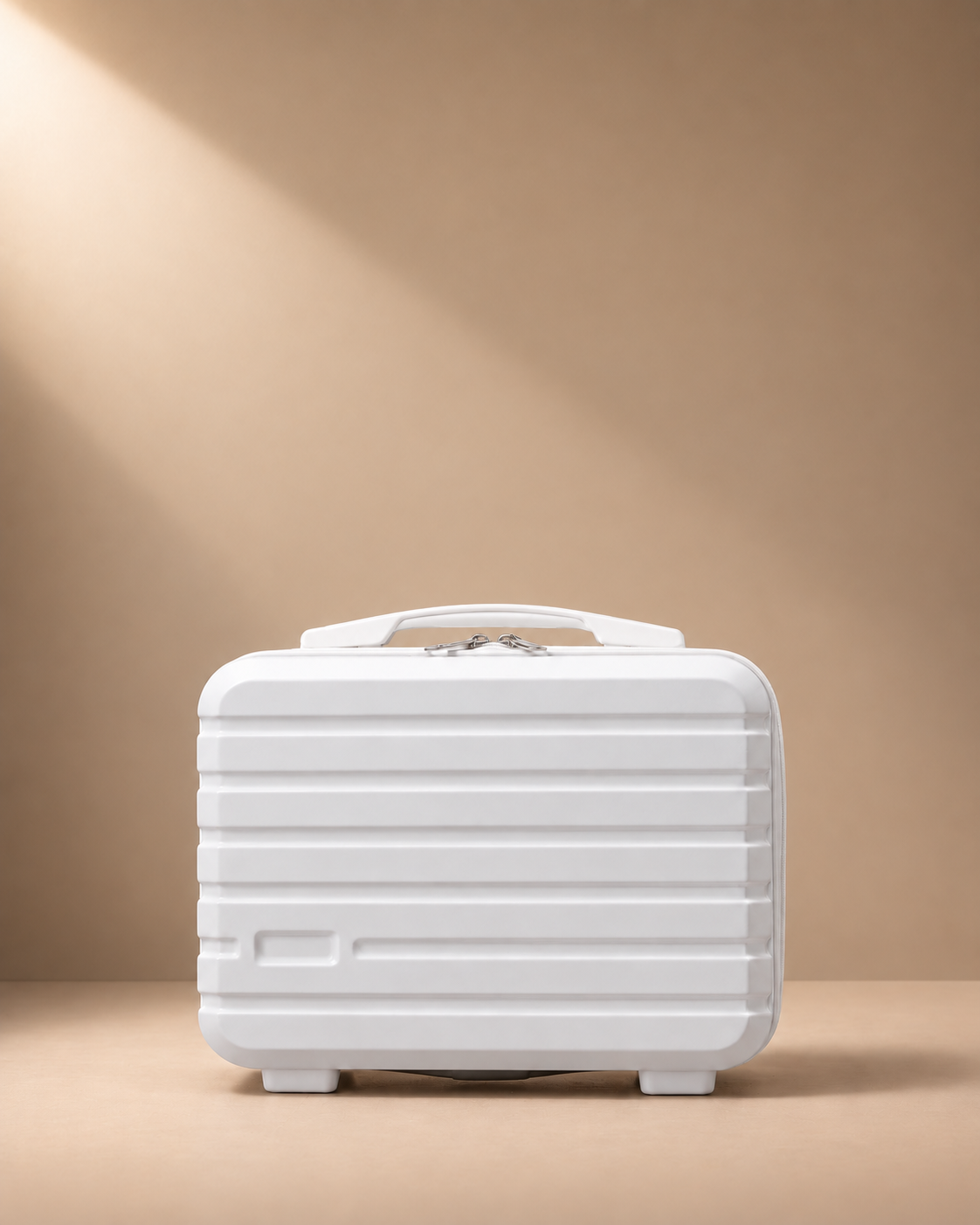 White mini suitcase cosmetic bag with hard shell, zip closure and top handle on beige studio background